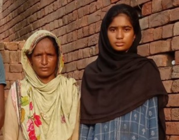 A girl stood next to a younger woman