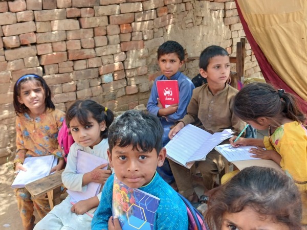 Six young children study in open air classroom