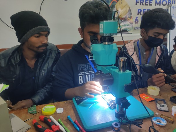 Three young men learning how to use tools