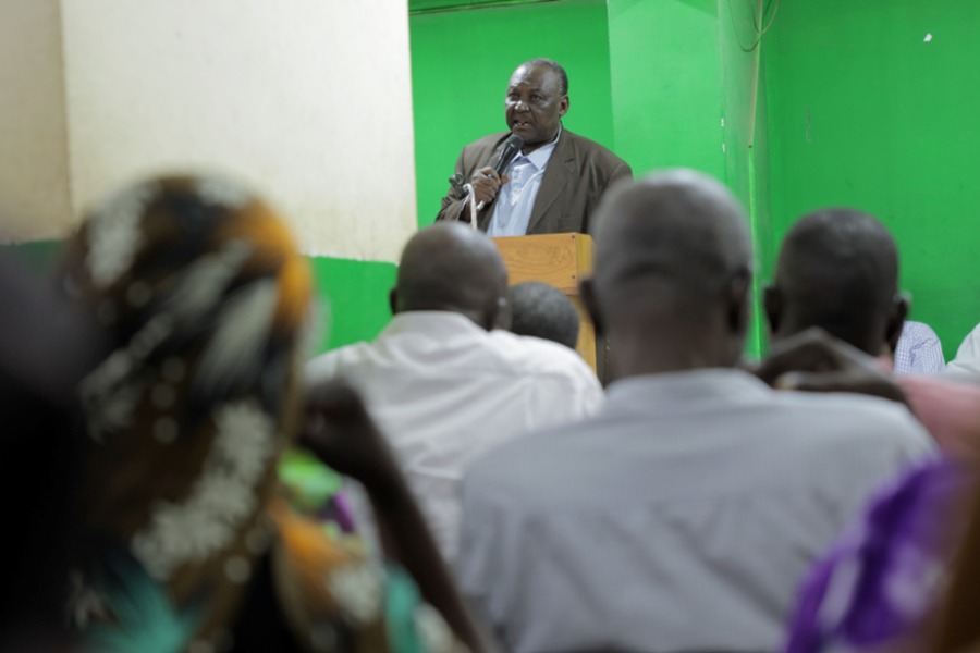 A man wearing a suit addresses a congregation