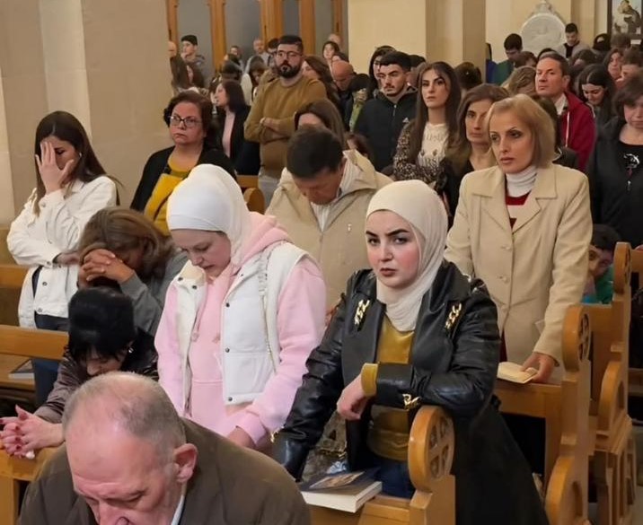 A group of men and women standing in a church service