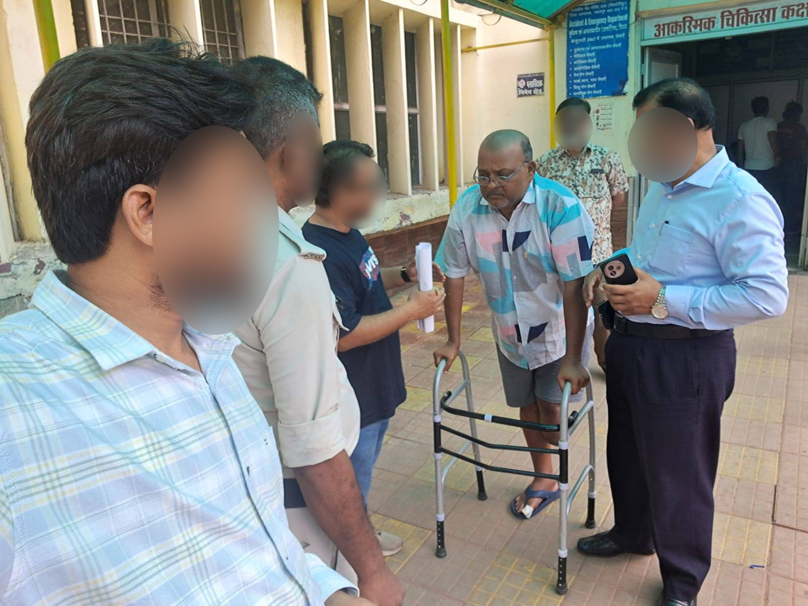 A man in a page shirt using a zimmer frame