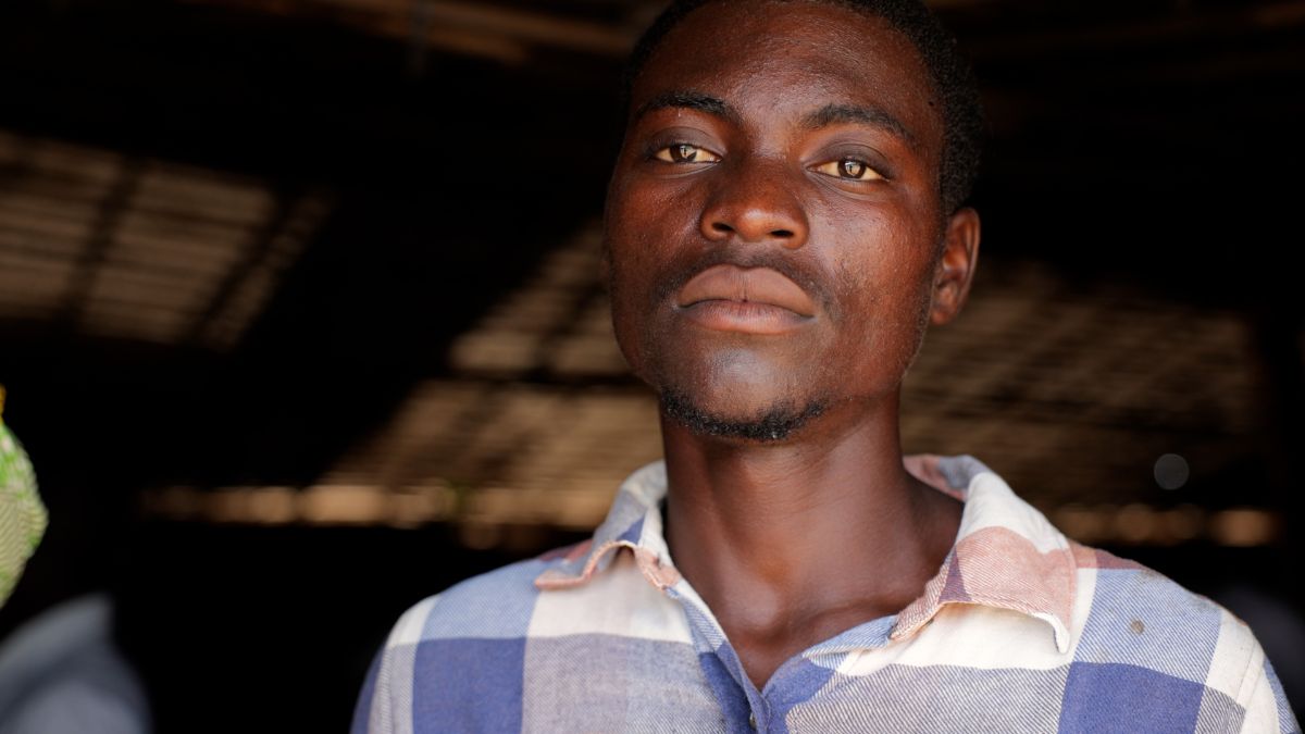 A young man in checked shirt inside a Church building made of Bamboo