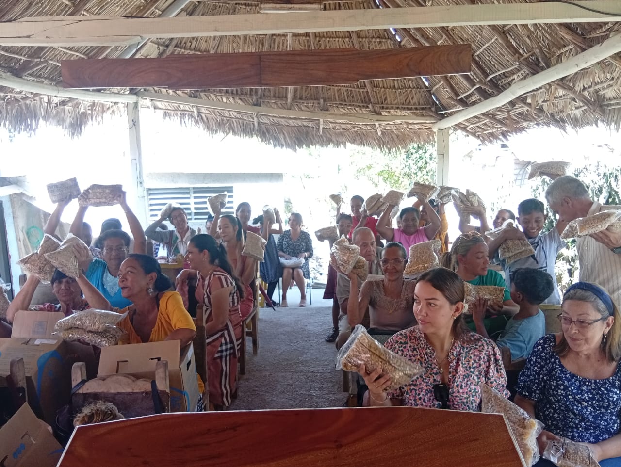 A congregation of people holding bags of dried soup mix