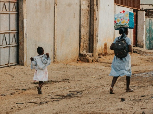 Two girls walking along a dirt track
