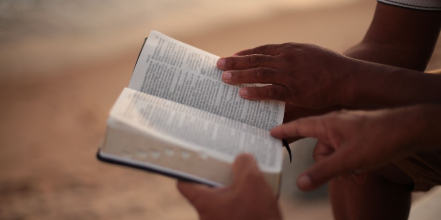 Hands holding an open Bible