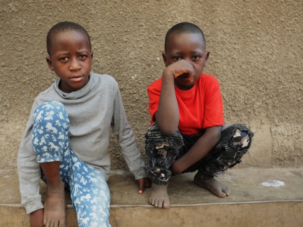 Two young children sitting on a wall