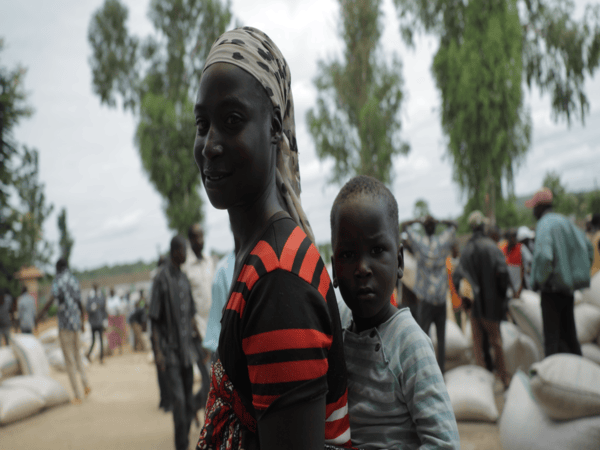 Woman carrying a baby on her back.