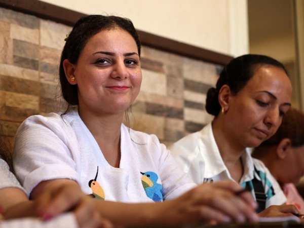 A woman in a white top holding a pencil