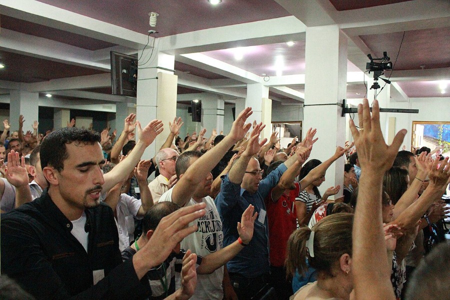 A group of people raising hands in worship