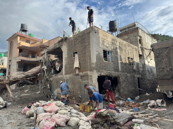 Several men working around a severely damaged building