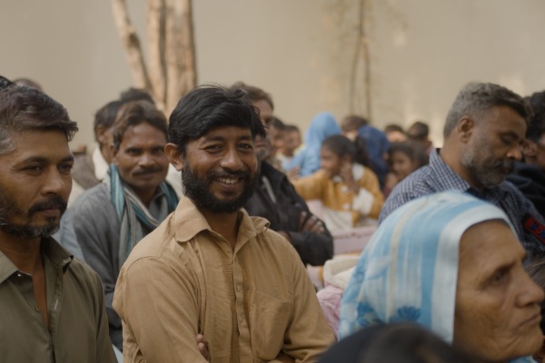 A smiling man sat with a group of people