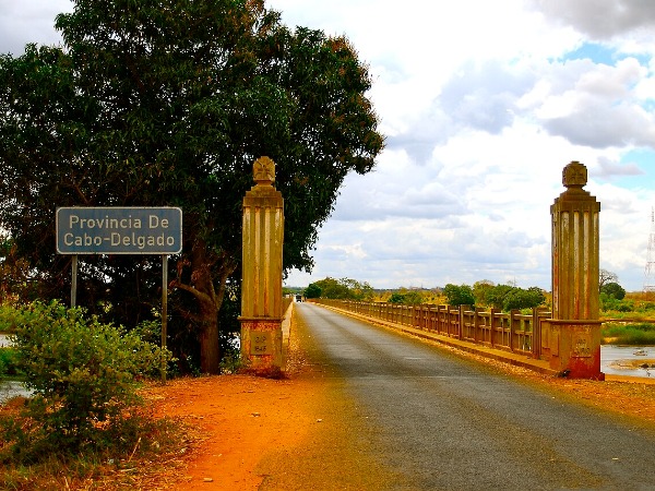 The entrance to a bridge, with a sign that says in Portuguese, "Province of Cabo Delgado"