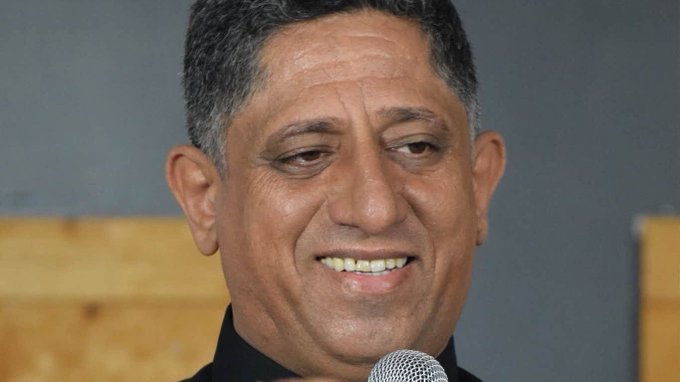 A man with dark hair holding a microphone