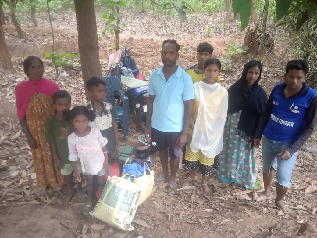 Ten people stood in the woods with a few bags and plastic chairs
