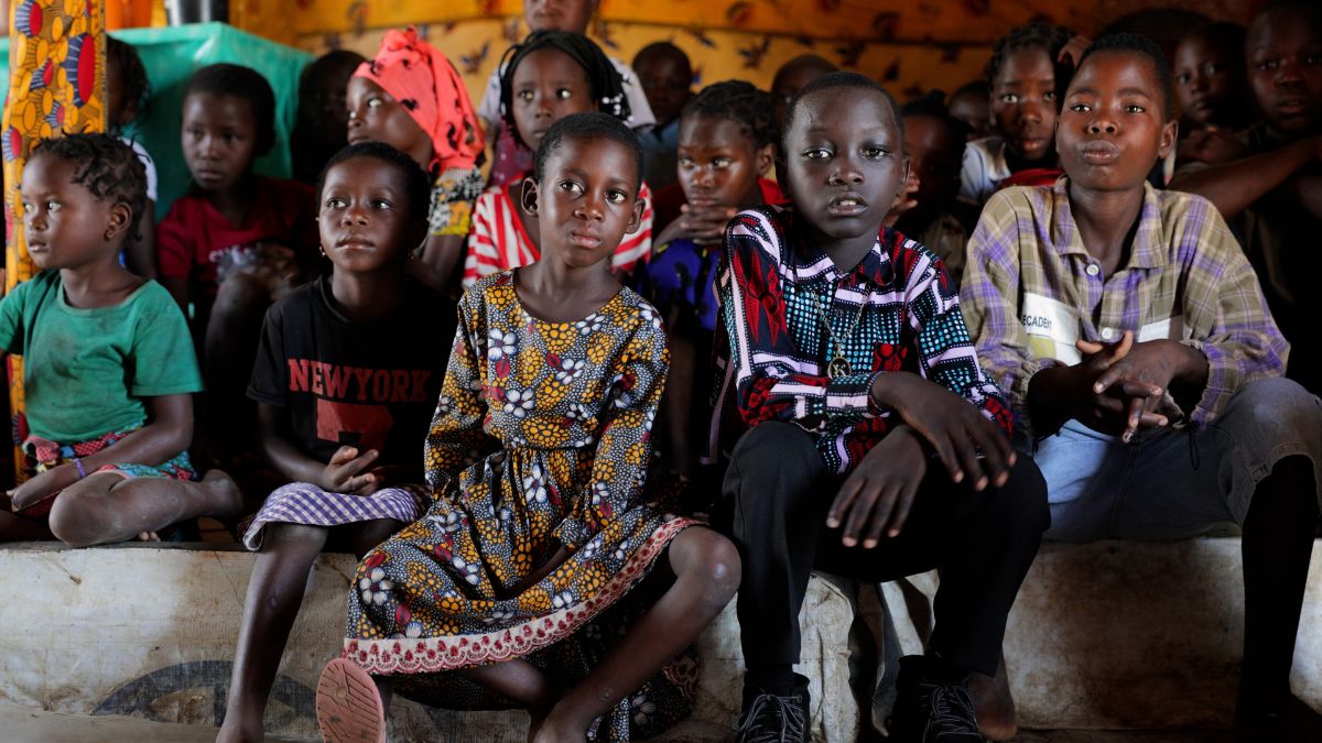 A group of children and young people in a basic church building