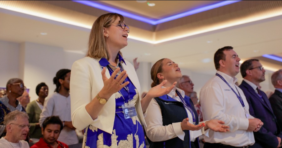 A group of people in a conference room singing