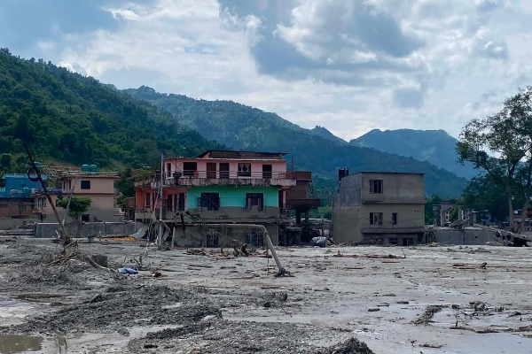 Damaged and destroyed buildings rise from a layer of mud