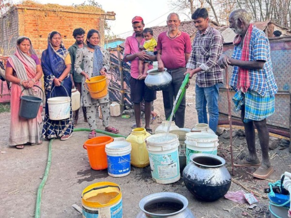 A group of people filling up buckets of water