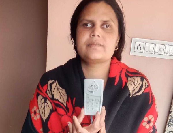 A woman holding a grey audio player