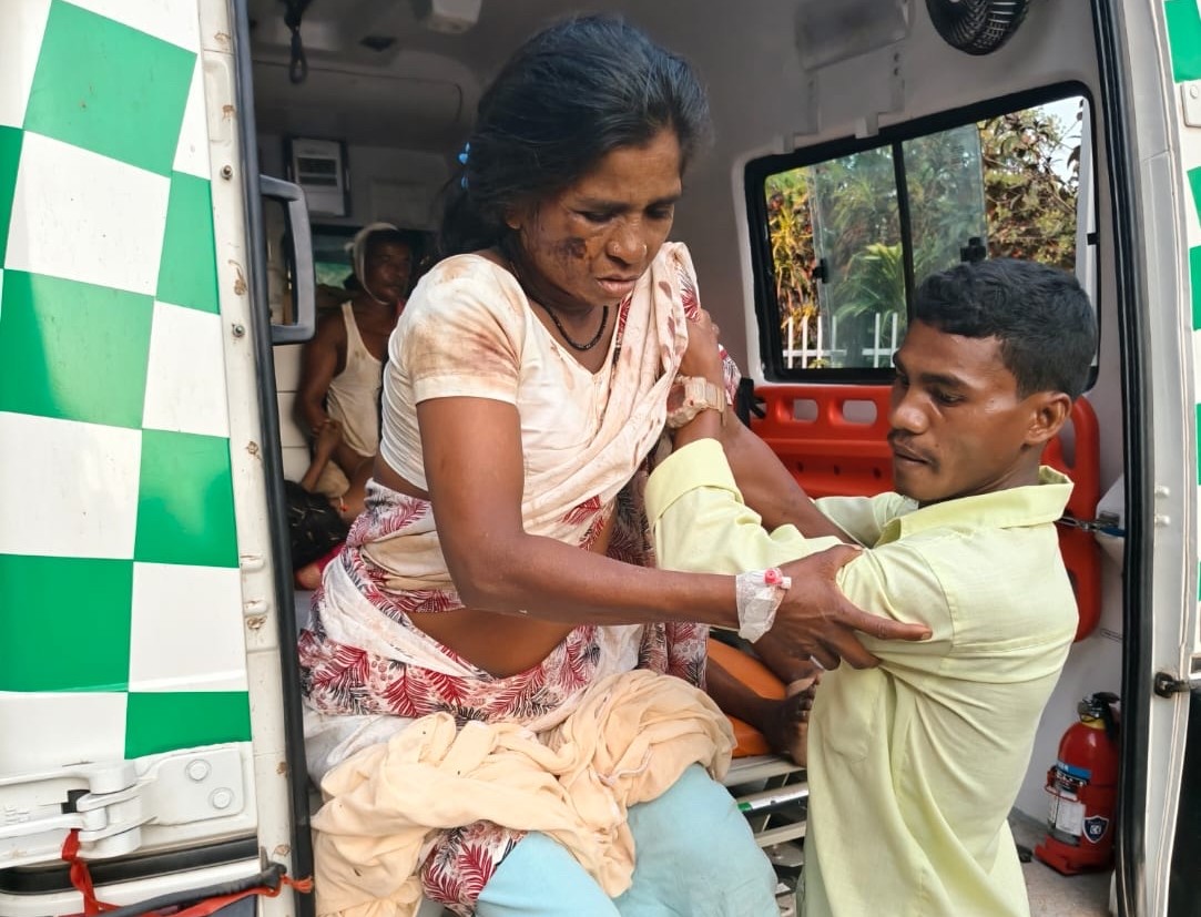 An injured woman is helped out of the back of an ambulance