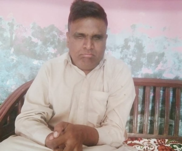 A man wearing a white shirt sat on a bench