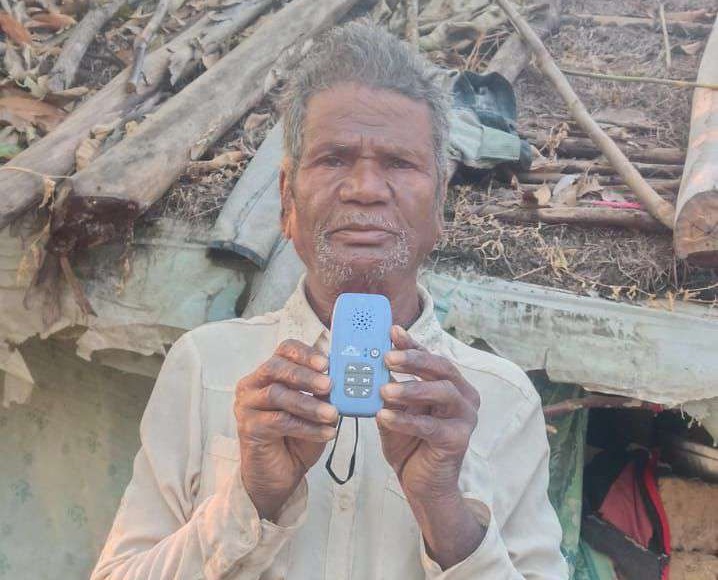 An older man holding a blue audio player