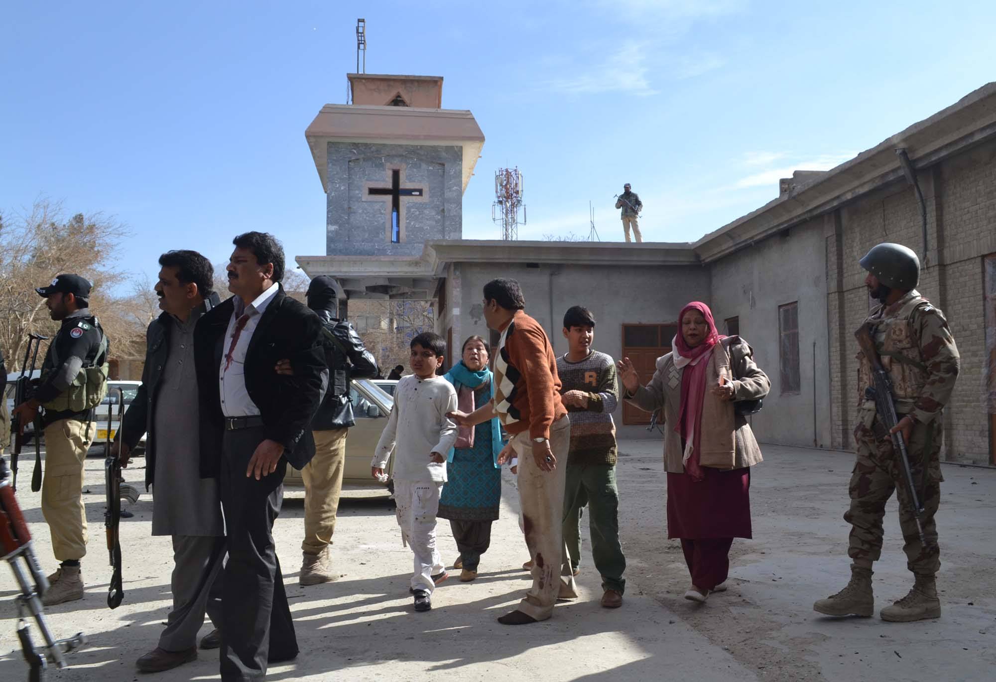People under protection of armed soldiers walking away from church building