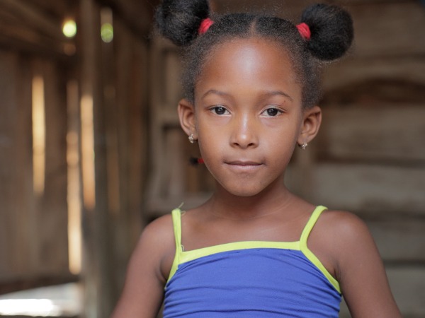 A young girl in a wooden shelter