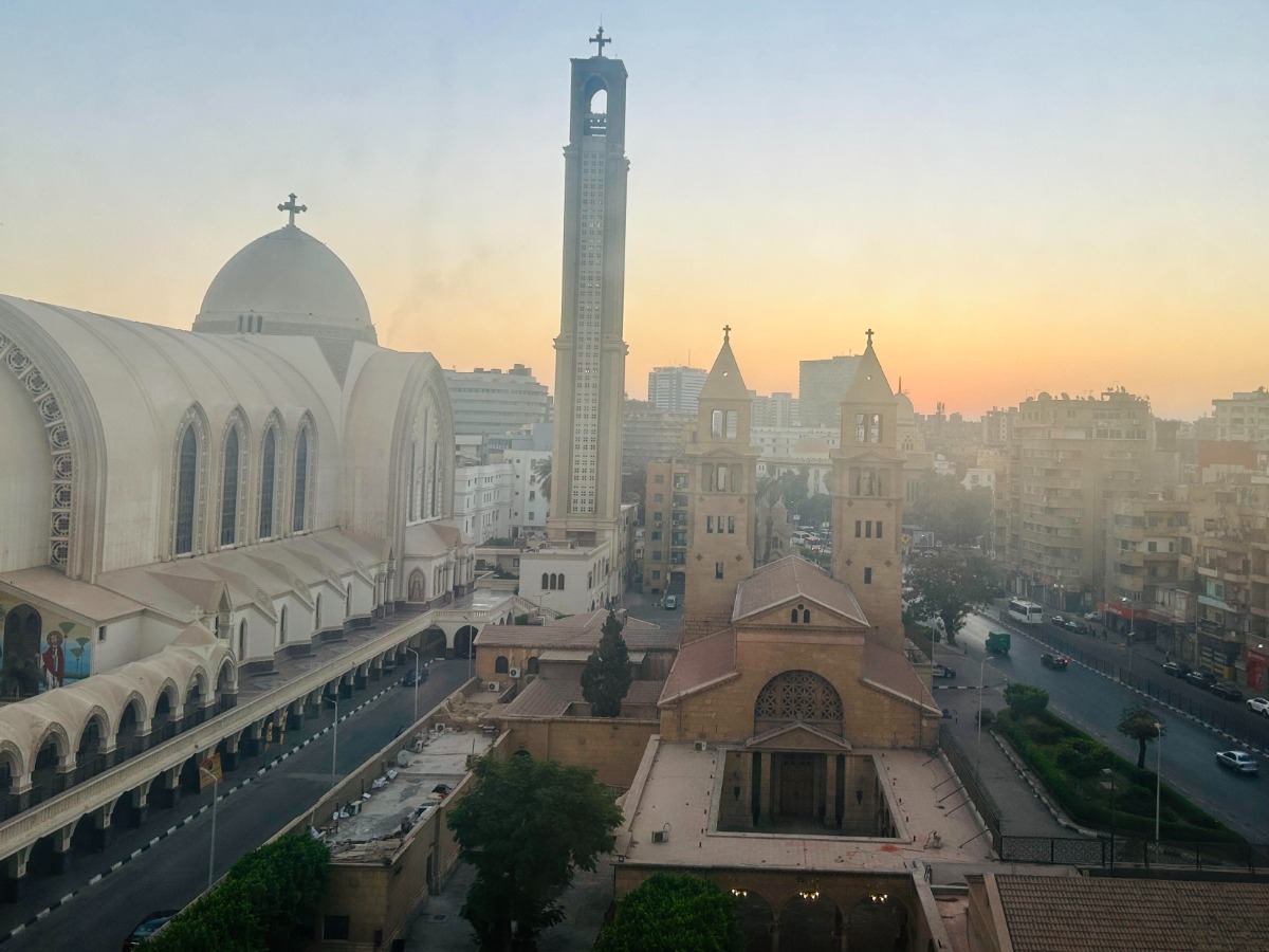 Several church buildings with crosses on the top adjacent to a busy street