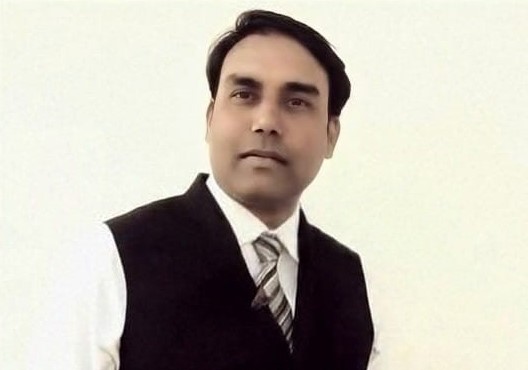 A man wearing white shirt, striped tie and dark waistcoat