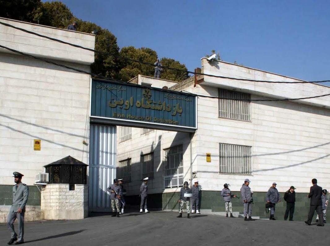 The entrance of a prison building with guards outside